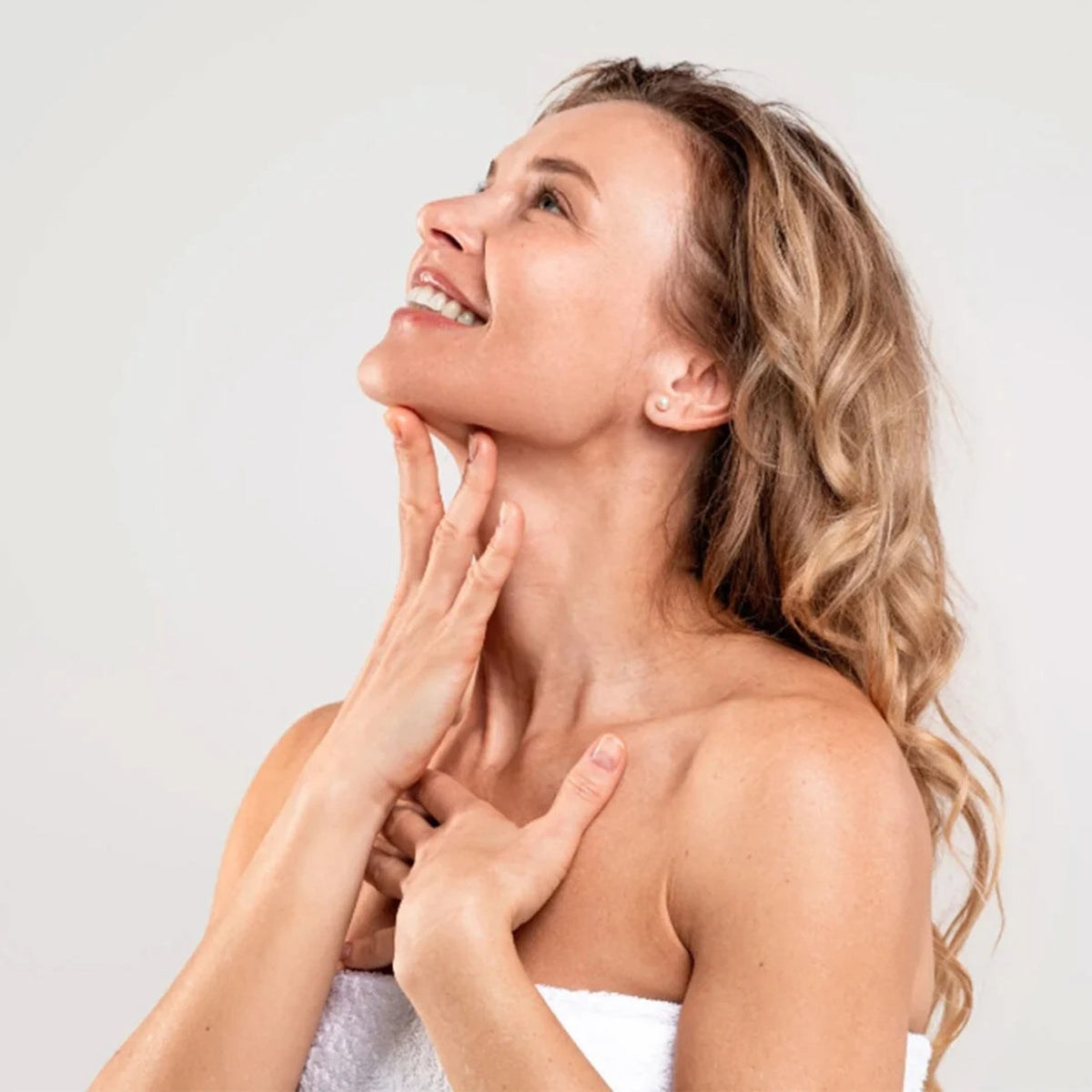 Mujer con piel firme y luminosa en cuello y escote tras mesoterapia facial Pink Glow